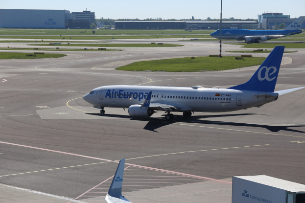 Air Europa Airbus A320-200 auf dem Rollfeld am Frankfurt Airport mit umliegender Wiese, Pfählen, Gebäuden, Bäumen und einem klaren blauen Himmel.