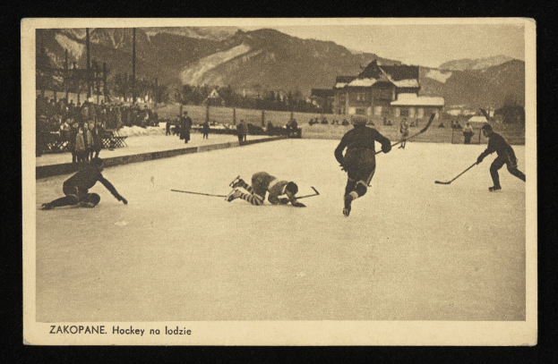 Ein Schwarz-Weiß-Foto von Menschen beim Eishockey auf einem Eisstadion, mit Gebäuden, Bäumen, Pfosten und Bergen im Hintergrund und Text unten.