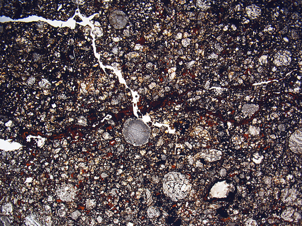 Nahaufnahme einer rissigen, schmutzigen Straße mit einer rauen, unebenen Oberfläche.