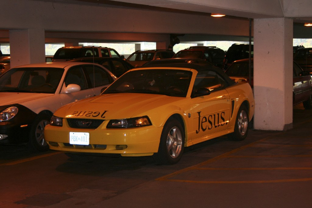 Ein Parkplatz mit zahlreichen parkenden Autos vor einem Gebäude.