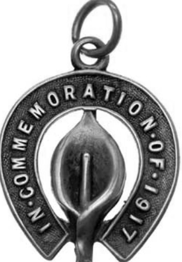 Silberne Medaille mit der Aufschrift "Feuergedächtnis" auf weißem Hintergrund.