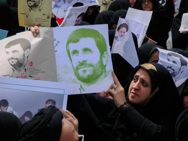 Eine Gruppe iranischer Frauen in schwarzer Kleidung, einige mit Brille, hält Fotos des iranischen Präsidenten Mahmoud Ahmadinejad während einer Demonstration in Tehran hoch.