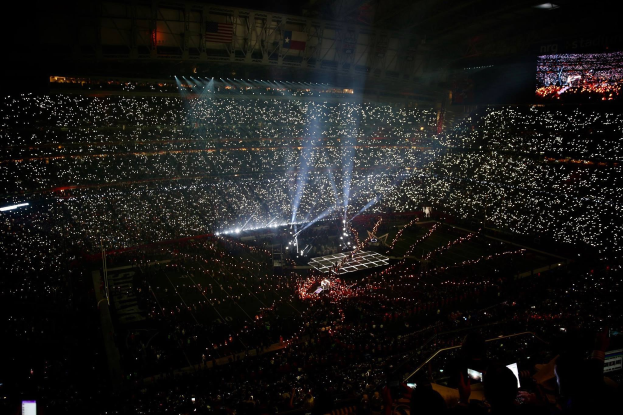 Gro├če Menge in hell erleuchtetem Stadion bei Nacht, mit einem Bildschirm rechts, der die Ergebnisse der Super Bowl XLVII-Halbzeitenshow anzeigt.