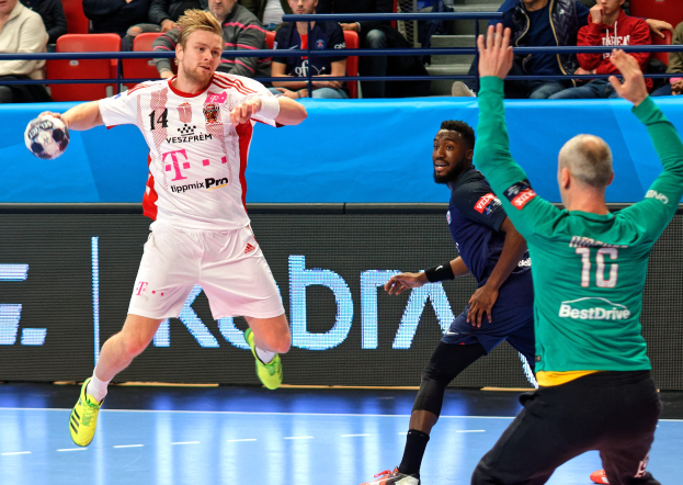 Männer spielen Hallenhandball auf einem Feld während des Futsal-Weltmeisterschaftsspiels 2019 zwischen Bayern München und Paris Saint-Germain, mit Zuschauern im Hintergrund.