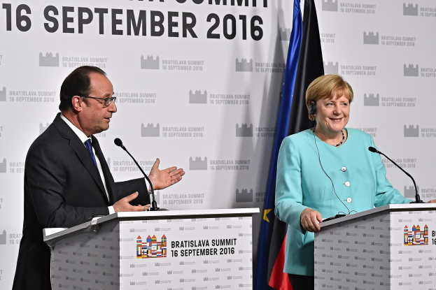 Bundeskanzlerin Angela Merkel und Frankreichs Präsident François Hollande stehen vor zwei Podien mit Mikrofonen, sie lächeln, mit einem "Bratislava-Gipfel 2016"-Schild dahinter.