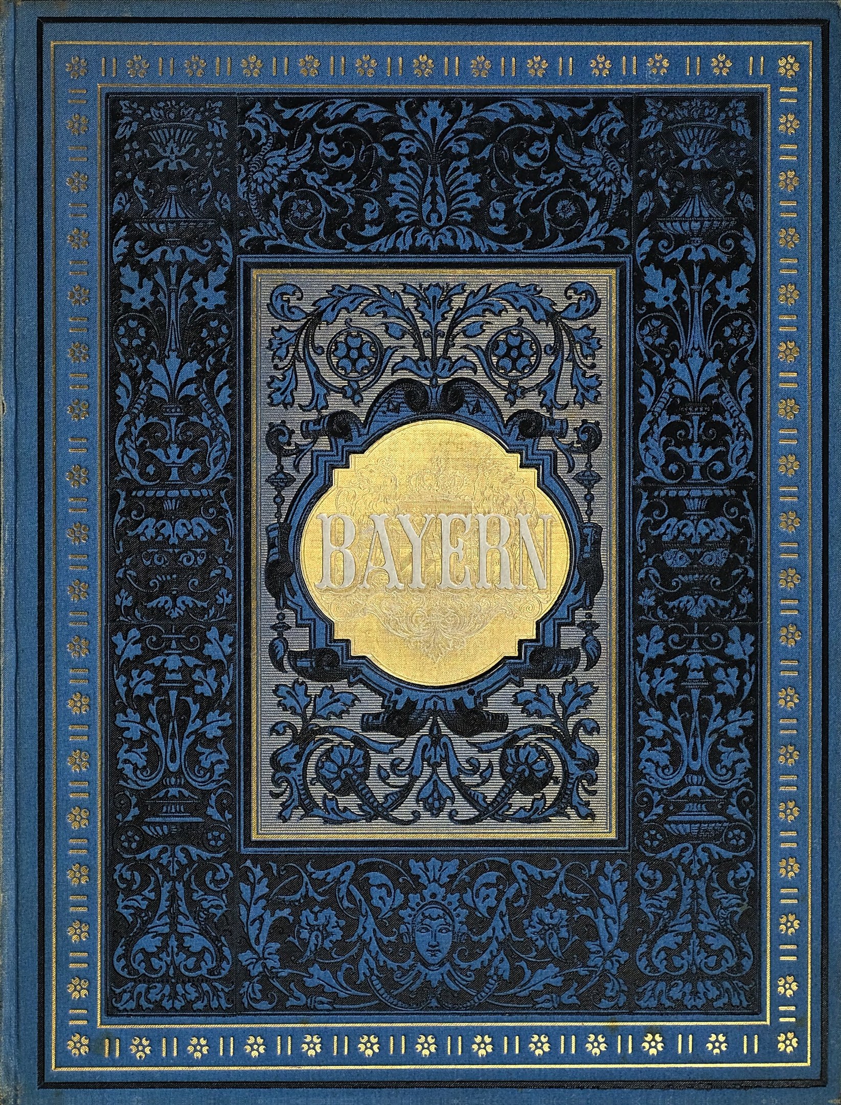 Ein blau-goldenes Buch mit dem Wort 'Bayern' auf dem Cover, das mit detaillierten Dekorationen versehen ist.