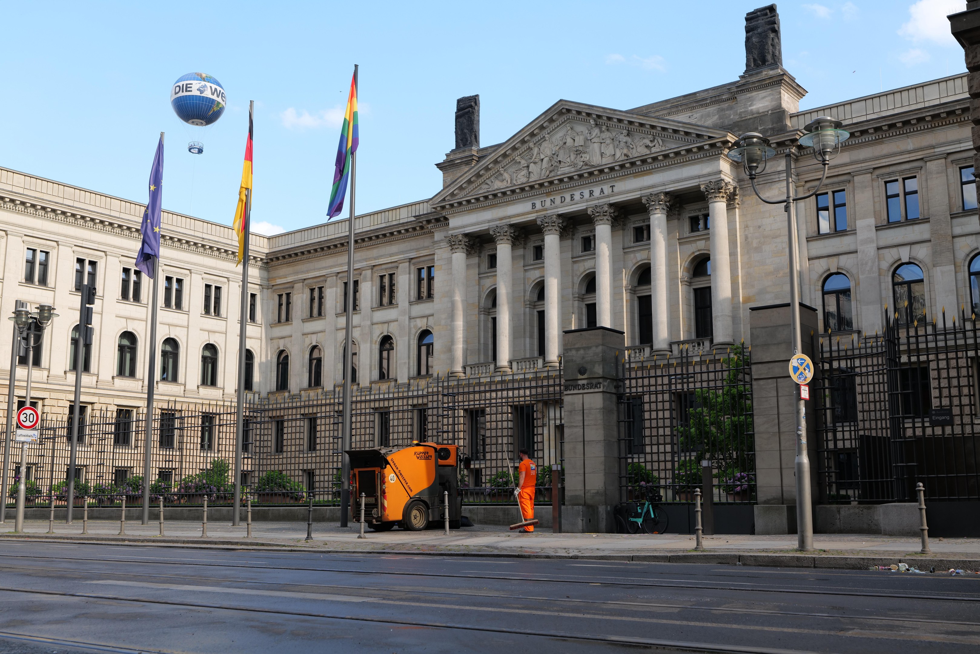 Großes modernes Regierungsgebäude mit vielen Fenstern, umgeben von Straßeninfrastruktur und Fußgängern, als Bundestag in Berlin, Deutschland identifiziert.