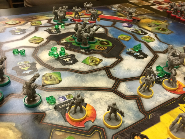 Ein Star-Wars: The-Old-Republic-Brettspiel im Gange, mit zahlreichen Miniaturen, die auf einem detaillierten Spielbrett für eine Schlacht Szene angeordnet sind, mit Stühlen und anderen Gegenständen im Hintergrund.