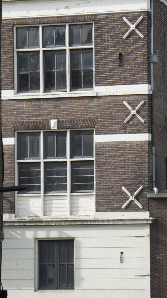 Ein Gebäude mit mehreren Fenstern und sichtbaren Rohren an seiner Außenseite.