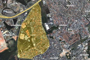 Luftaufnahme einer Stadt mit dichtem Baumbestand, Straßen, Bäumen und Gras, mit einer zentralen Karte, die eine geplante Baustelle markiert.