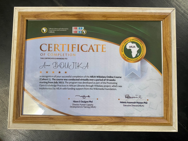 Ein gerahmtes Abschlusszertifikat liegt auf einem Tisch, mit Text, der den Abschluss eines Kurses anzeigt.