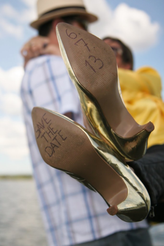 Frauen-High-Heels mit Aufschrift, mit einer Person, die sie von hinten hält.