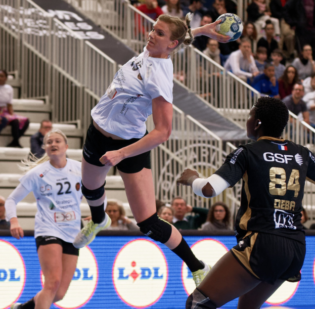 Eine Gruppe von Frauen spielt Handball auf einem Platz mit einem Ball in der Luft, während Zuschauer von hinten zusehen, während der Handball-Weltmeisterschaft 2019 - Tag 2.