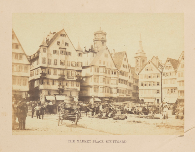Altes Schwarz-Weiß-Foto eines belebten Marktplatzes in Stuttgart, Deutschland, mit mehrstöckigen Gebäuden, Passanten, horse-drawn carts und verschiedenen Marktständen; handgeschriebener Text erscheint entlang der unteren Kante.