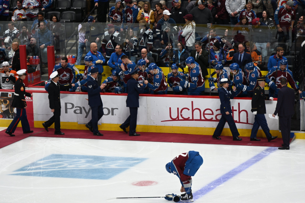 Eishockeyspieler auf dem Eis von Fans und Teammitgliedern umgeben während eines NHL-Spiels zwischen Colorado Avalanche und San Jose Sharks am 24. März 2015.