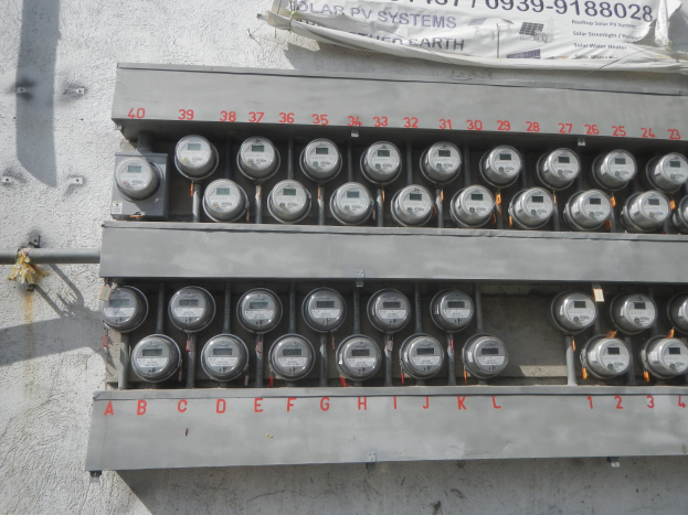 Nahaufnahme eines Stromzählers an der Seite eines Gebäudes mit einem Banner oben mit Text.